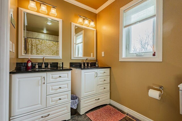 bathroom featuring vanity, crown molding, toilet, and baseboards