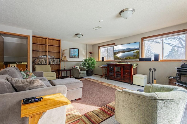 living room featuring visible vents, a textured ceiling, and carpet floors