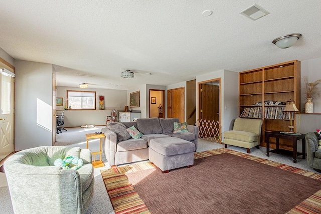 carpeted living room featuring visible vents and a textured ceiling