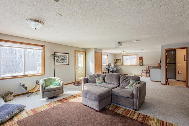 living room featuring baseboards, carpet floors, plenty of natural light, and a textured ceiling