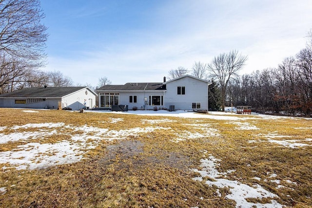 snow covered house featuring a sunroom