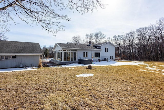 back of property featuring a lawn, a chimney, a patio, and a sunroom