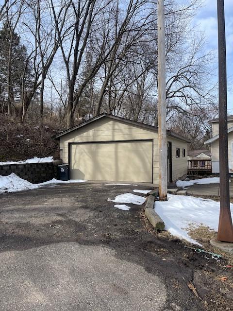 snow covered garage featuring a detached garage