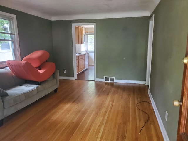 sitting room with visible vents, baseboards, and wood finished floors