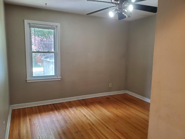 spare room with baseboards, a ceiling fan, and wood finished floors