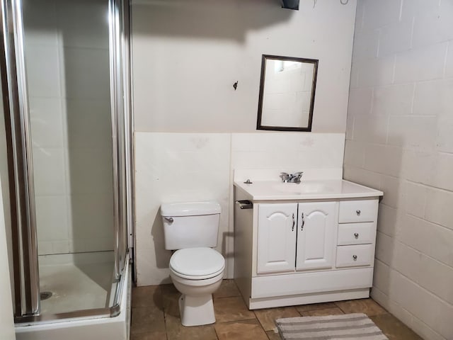 full bath with a wainscoted wall, toilet, a stall shower, tile walls, and vanity