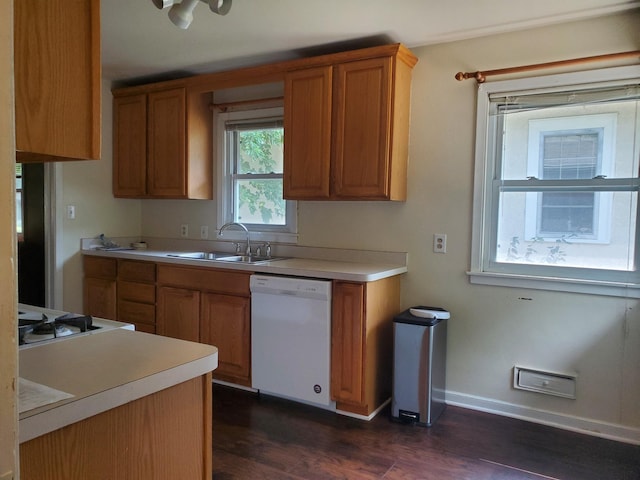 kitchen featuring brown cabinetry, dishwasher, and a sink