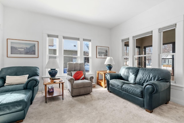 living room featuring light colored carpet, baseboards, and a healthy amount of sunlight