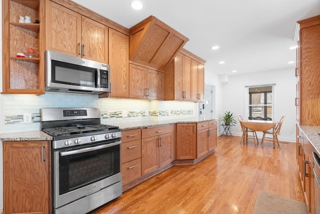 kitchen with light stone counters, light wood finished floors, recessed lighting, stainless steel appliances, and decorative backsplash