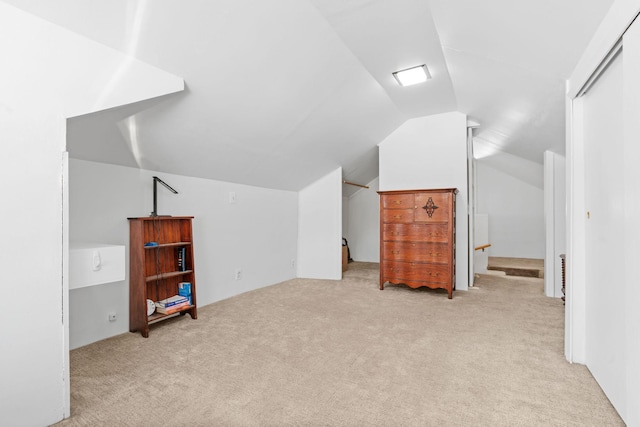 additional living space featuring carpet flooring and vaulted ceiling