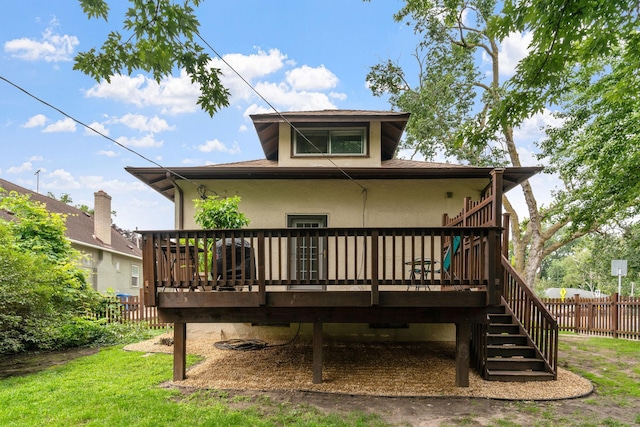 back of house featuring stairway, stucco siding, a deck, and fence