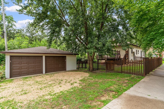 view of yard with a fenced front yard, an outbuilding, and a garage