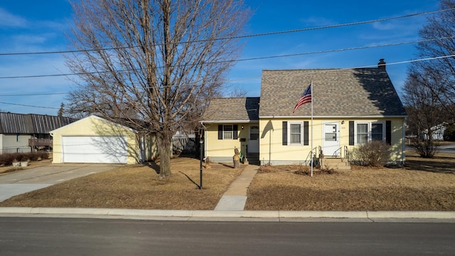 new england style home featuring a detached garage, roof with shingles, and an outdoor structure