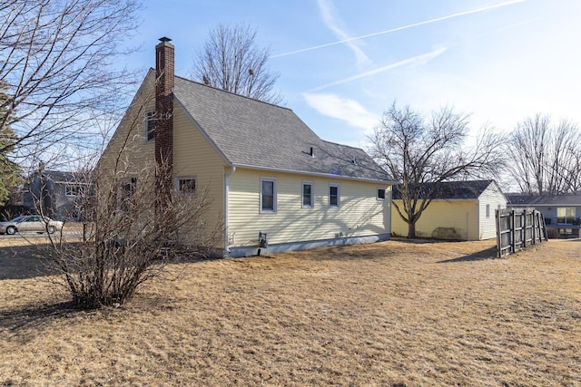 view of property exterior featuring fence, a chimney, and a shingled roof