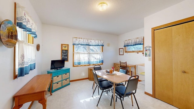 dining space with light floors and baseboards