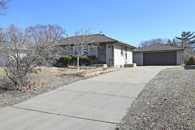 ranch-style home featuring an outbuilding, a shingled roof, and a garage