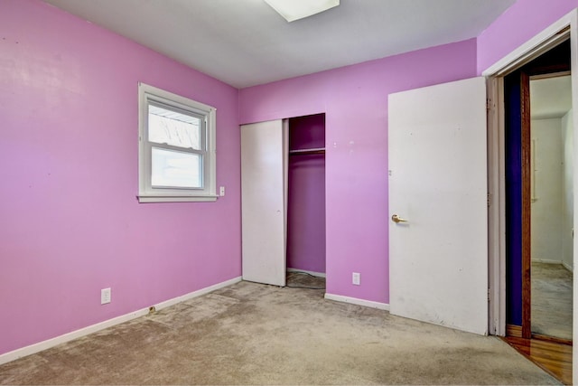 unfurnished bedroom with carpet flooring, baseboards, and a closet