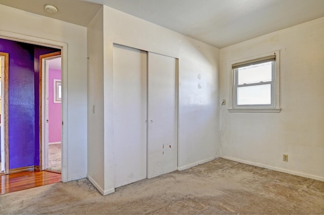 unfurnished bedroom with a closet and light carpet