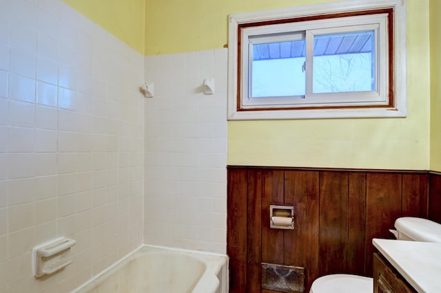 full bathroom with a wainscoted wall, shower / bathtub combination, toilet, and vanity