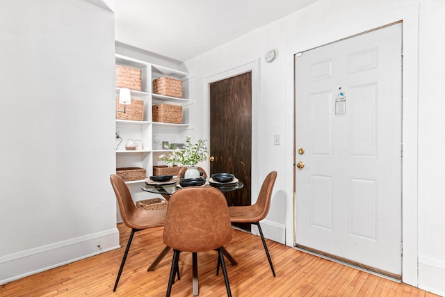 dining space featuring light wood-type flooring and baseboards