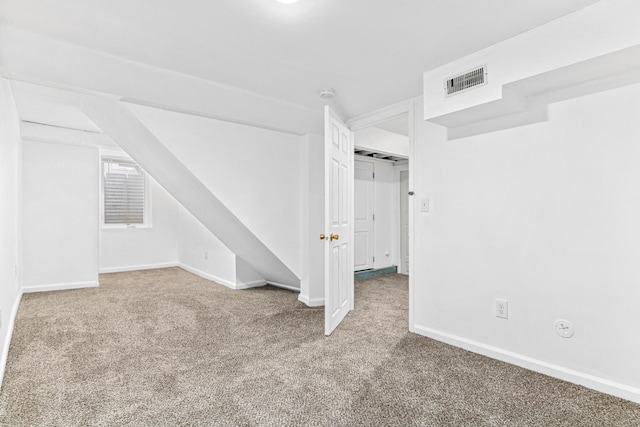 finished basement with visible vents, carpet floors, and baseboards