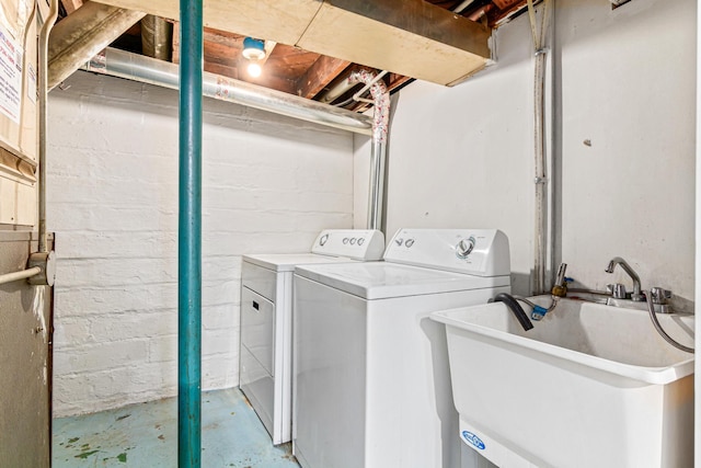 laundry room featuring washer and clothes dryer, laundry area, and a sink