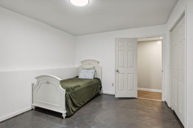 bedroom featuring finished concrete flooring and baseboards