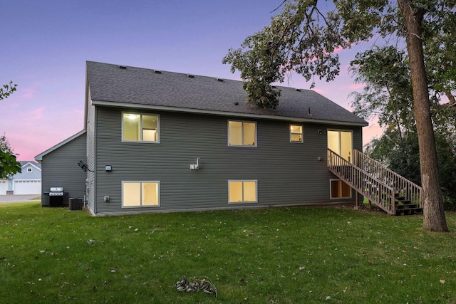 back of property featuring a yard, central AC unit, and stairway