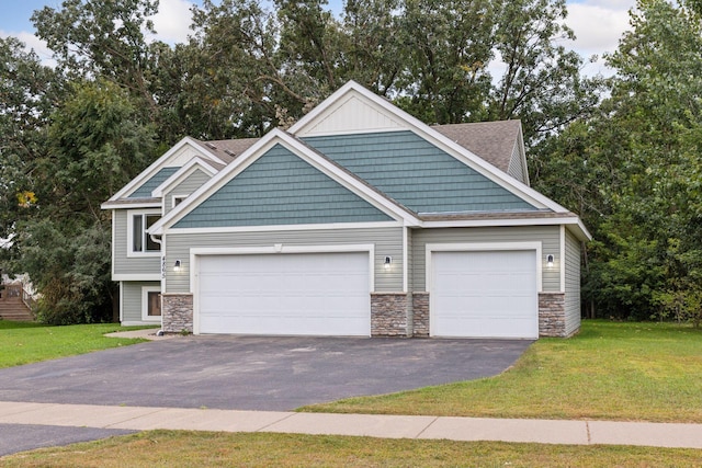 view of front of house with a front yard, an attached garage, stone siding, and driveway