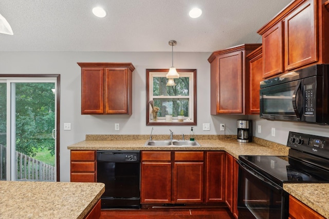 kitchen with black appliances, pendant lighting, a sink, recessed lighting, and light countertops