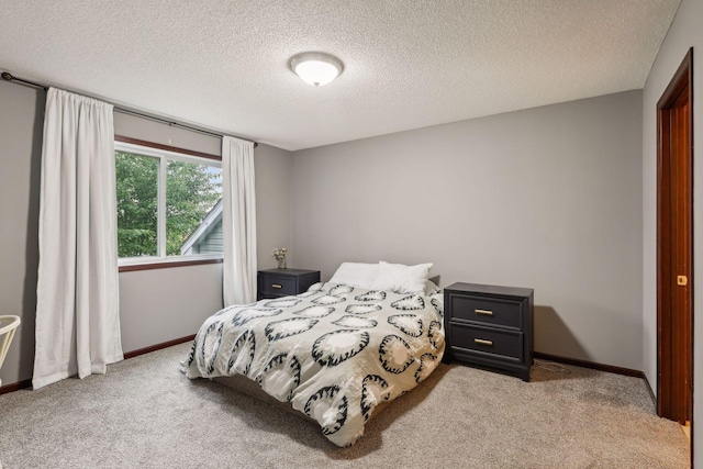 bedroom with carpet, baseboards, and a textured ceiling