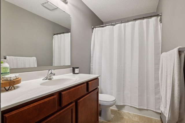 bathroom with tile patterned flooring, toilet, vanity, and a textured ceiling