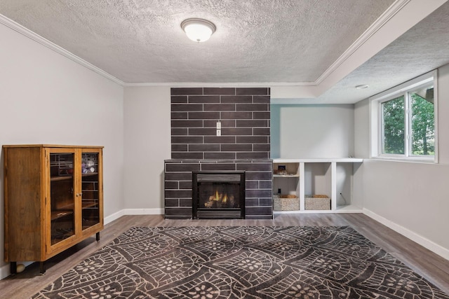 unfurnished living room featuring a large fireplace, wood finished floors, and crown molding