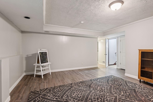 interior space with a textured ceiling, baseboards, and wood finished floors