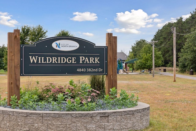 community / neighborhood sign featuring a yard