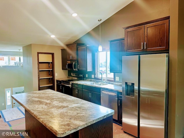 kitchen featuring a kitchen island, decorative light fixtures, light countertops, stainless steel appliances, and a sink