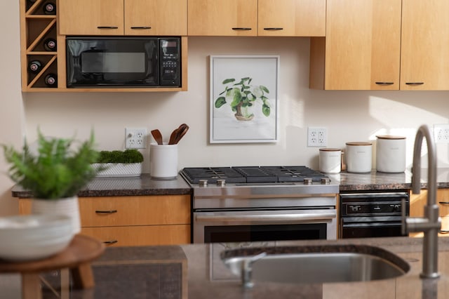 kitchen with stainless steel range with gas stovetop, wall oven, and black microwave