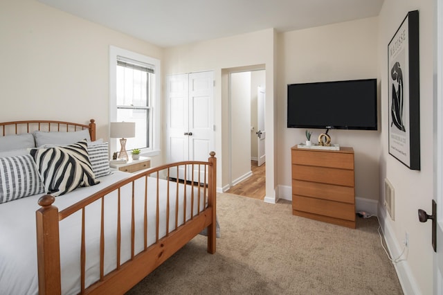 bedroom with a closet, visible vents, baseboards, and carpet