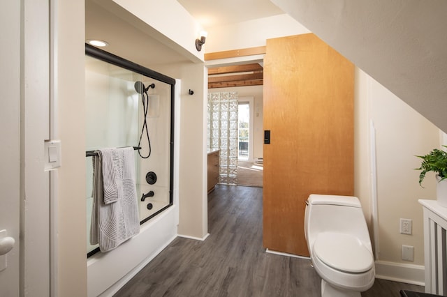 full bath featuring baseboards, enclosed tub / shower combo, toilet, and wood finished floors