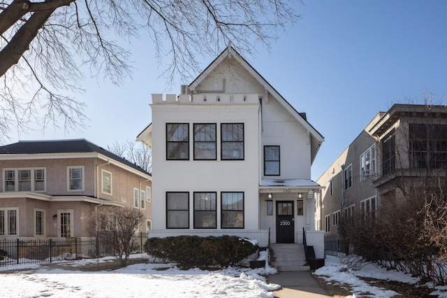 view of front facade featuring stucco siding and fence