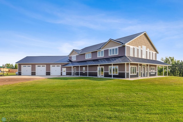 view of front of home with a front lawn, driveway, metal roof, a sunroom, and a garage