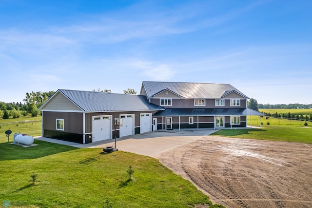 view of front facade featuring a garage, driveway, metal roof, and a front lawn