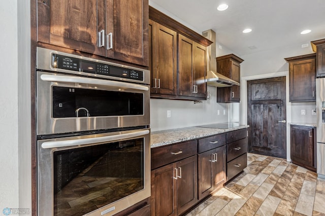 kitchen with dark brown cabinetry, light stone counters, recessed lighting, and appliances with stainless steel finishes