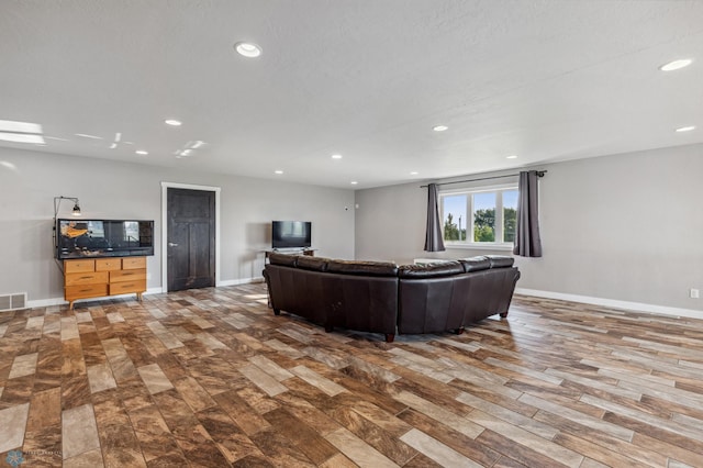 living area with recessed lighting, visible vents, baseboards, and wood finished floors