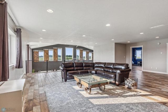 living room with recessed lighting, wood finished floors, and vaulted ceiling