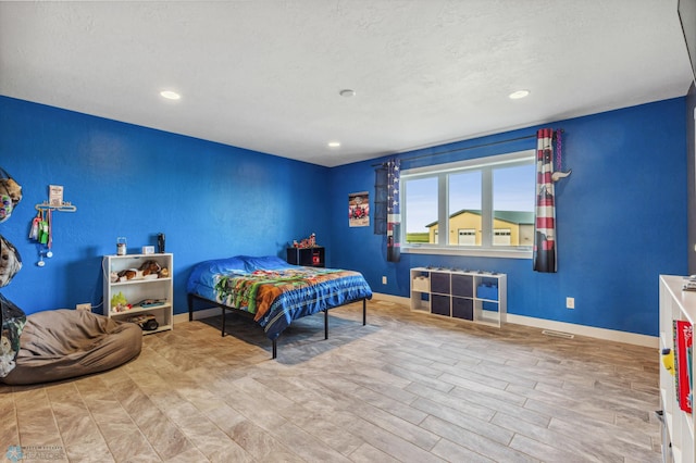 bedroom with recessed lighting, baseboards, a textured ceiling, and wood finished floors