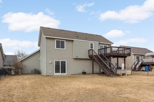 rear view of house with stairway, central air condition unit, a lawn, a fenced backyard, and a deck