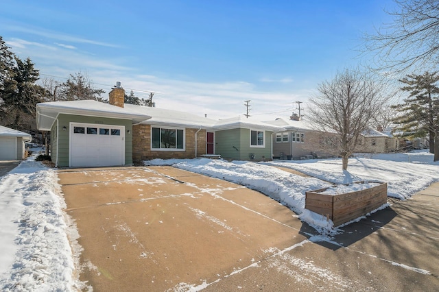 ranch-style home with a chimney, concrete driveway, and an attached garage