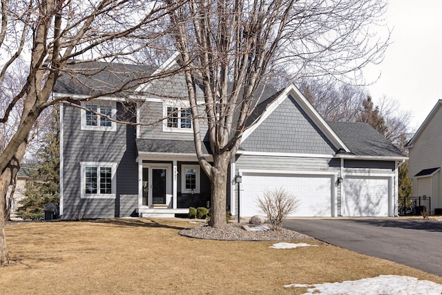 view of front of home featuring aphalt driveway, a front yard, a garage, and a shingled roof