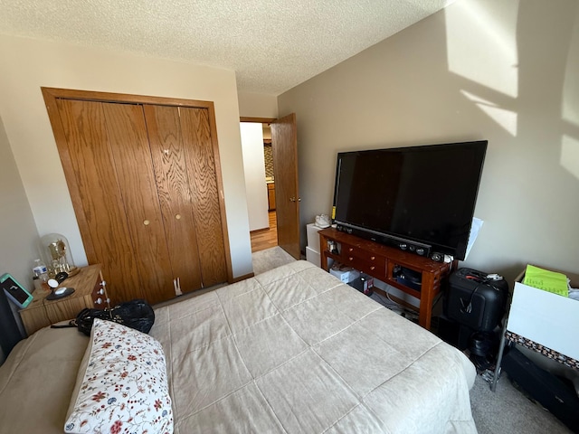 carpeted bedroom featuring a closet and a textured ceiling